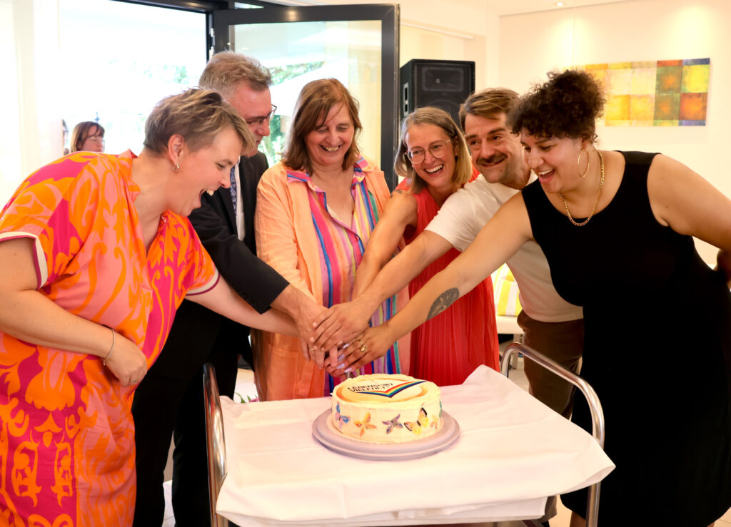 Torte Qualitätssiegel wird gemeinsam von sechs Personen angeschnitten